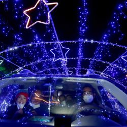 Una familia observa las luces navideñas al pasar por el  | Foto:Ulises Ruiz / AFP