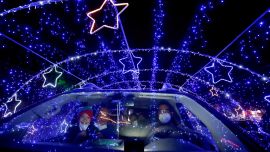 Una familia observa las luces navideñas al pasar por el