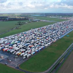Los camiones de carga y los vehículos pesados de mercancías (HGV) se apilan en el aeropuerto de Manston cerca de Ramsgate, al sureste de Inglaterra, donde el transporte de carga se desvió para esperar, después de que Francia cerró sus fronteras durante 48 horas para contener la propagación de una nueva cepa de coronavirus. | Foto:William Edwards / AFP