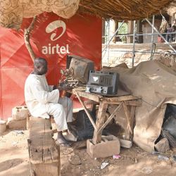 Un hombre repara televisores viejos en la calle de Niamey. | Foto:Issouf Sanogo / AFP