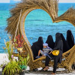 Un hombre toma fotos de un grupo de mujeres musulmanas con niqabs en una playa de la isla de Koh Lipe. | Foto:Mladen Antonov / AFP