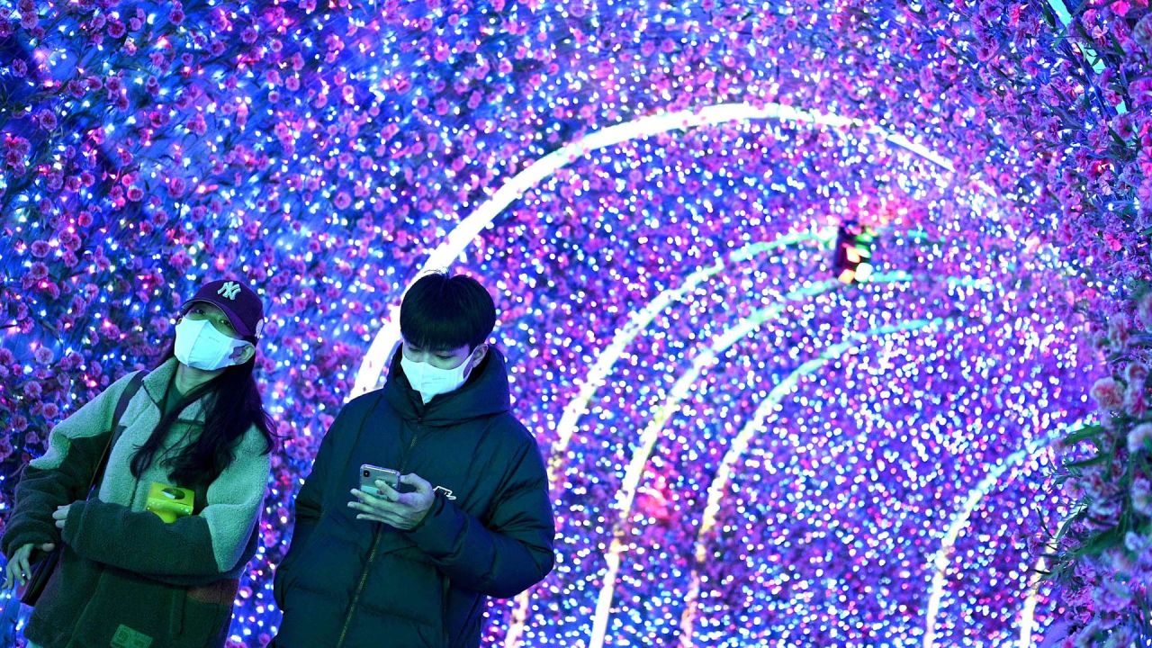 Las personas usan sus teléfonos móviles mientras caminan en un centro comercial en Beijing. | Foto:Noel Celis / AFP