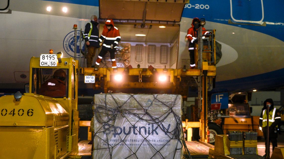 Handout photo released by Presidency shows workers loading 300,000 doses of the Sputnik V vaccine against Covid-19, onto an Aerolíneas Argentinas plane at Sheremetyevo international airport, near Moscow on December 23, 2020. 