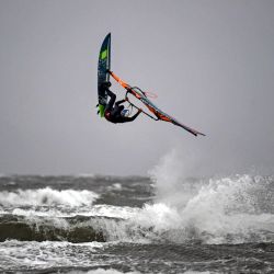 Un windsurfista realiza un truco en la playa de Barassie en Troon, en la costa oeste de Escocia, cuando la tormenta Bella trae lluvia y fuertes vientos al Reino Unido. | Foto:Andy Buchanan / AFP
