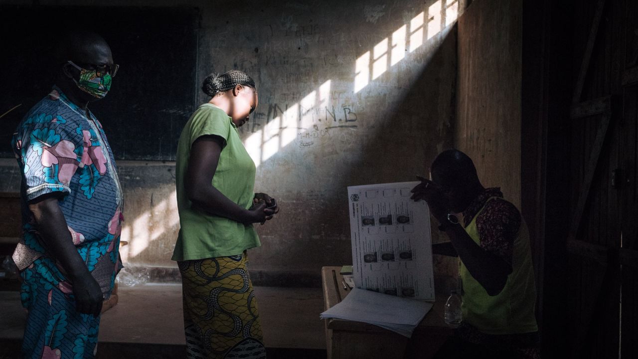 Los votantes esperan mientras los funcionarios de la comisión electoral verifican la lista de votantes en el colegio electoral de la escuela secundaria Barthélemy Boganda en el primer distrito de Bangui, República Centroafricana (RCA), durante las elecciones presidenciales y legislativas del país. | Foto:Añlexis Huguet / AFP