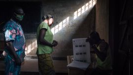 Los votantes esperan mientras los funcionarios de la comisión electoral verifican la lista de votantes en el colegio electoral de la escuela secundaria Barthélemy Boganda en el primer distrito de Bangui, República Centroafricana (RCA), durante las elecciones presidenciales y legislativas del país.