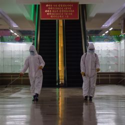 Los trabajadores de la salud rocían desinfectante dentro de los grandes almacenes No. 1 de Pyongyang antes de abrir sus puertas, en Pyongyang. | Foto:KIM Won Jin / AFP