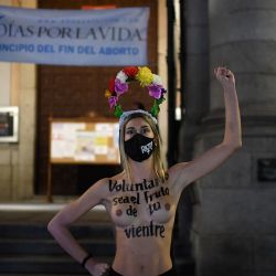 Una activista de Femen con el pecho desnudo leyendo en español  | Foto:Oscar Del Pozo / AFP