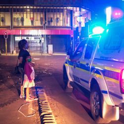 Una mujer y un niño le explican a un oficial del Servicio de Policía de Sudáfrica mientras todavía están en la calle después del nuevo toque de queda, para ayudar a frenar la propagación del COVID-19, en Johannesburgo. | Foto:Wikus de Wet / AFP