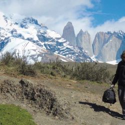 Miembros de la caravana caminan con la torres como telón del fondo.