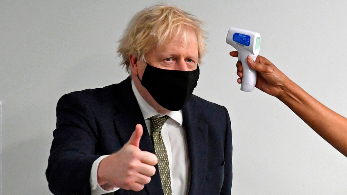 Prime Minister Boris Johnson gives a thumbs up as he has his temperature checked during a visit to Chase Farm Hospital in north London on January 4, 2021.