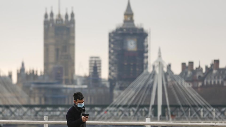 Un hombre camina por el puente Waterloo con las Cámaras del Parlamento en el fondo, en Londres, Reino Unido, el 29 de diciembre de 2020. Otras 41.385 personas en Reino Unido dieron positivo por la COVID-19, la cifra más alta en un solo día desde que comenzó la pandemia en el país, se indicó en cifras oficiales dadas a conocer el lunes.
