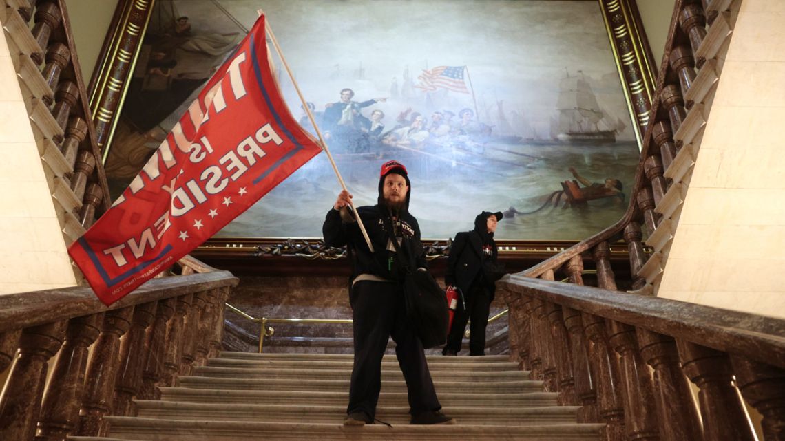 A protester holds a Trump flag inside the US Capitol Building near the Senate Chamber on January 06, 2021 in Washington DC. Congress held a joint session today to ratify President-elect Joe Biden's 306-232 Electoral College win over President Donald Trump. A group of Republican senators said they would reject the Electoral College votes of several states unless Congress appointed a commission to audit the election results. 