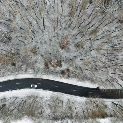 Una vista aérea muestra un automóvil conduciendo por una calle de un paisaje invernal en la montaña Nordhelle cerca de Meinerzhagen, Alemania occidental. | Foto:Ina Fassbender / AFP