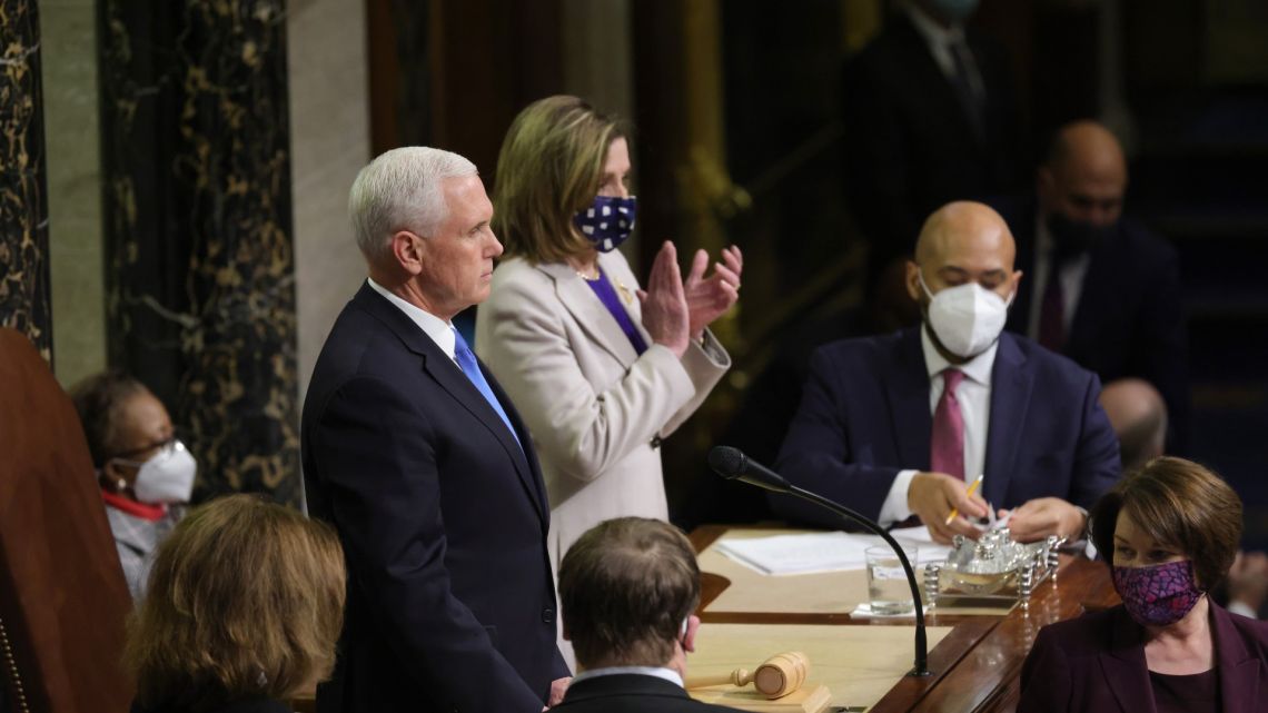 US Vice-President Mike Pence (left) and US Speaker of the House Nancy Pelosi (Democrat-California) look on as the the count of electoral votes continues in the House Chamber during a reconvening of a joint session of Congress on January 07, 2021 in Washington DC. 