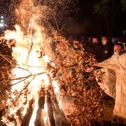Un sacerdote ortodoxo serbio participa en una ceremonia de hoguera en el monasterio de Gracanica durante la quema ceremonial de ramas de roble secas, que simboliza el tronco de Yule durante las celebraciones ortodoxas de Nochebuena en Gracanica. | Foto:Armend Nimani / AFP