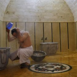 Un hombre se lava en el histórico y renovado Al-Jadid Hammam (casa de baños de estilo turco) que fue restaurado después de sufrir graves daños durante las batallas entre las fuerzas del régimen sirio y los combatientes rebeldes en la ciudad de Alepo. | Foto:AFP