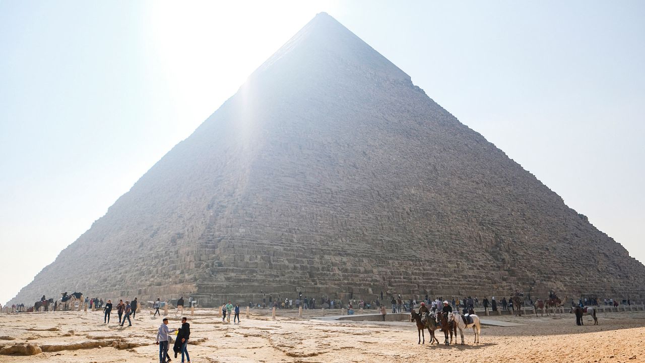 Los turistas caminan cerca de la base de la pirámide de Khafra en la necrópolis de las pirámides de Giza en las afueras occidentales de la ciudad gemela de Giza, la capital egipcia. | Foto:Amir Makar / AFP