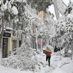 La gente camina sobre ramas caídas en Madrid en medio de una fuerte nevada. - Las tormentas de nieve en gran parte de España dejaron tres muertos y provocaron el caos en gran parte del país, atrapando a los automovilistas y cerrando las conexiones aéreas y ferroviarias de la capital, con más caídas. venir. | Foto:Gabriel Bouys / AFP