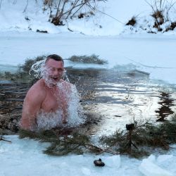 Esta fotografía publicada por el servicio de prensa del alcalde de Kiev muestra al alcalde Vitali Klitschko, ex campeón mundial de boxeo de peso pesado, bañándose en un lago en Kiev durante la celebración de la fiesta de la Epifanía Ortodoxa. | Foto:Handout / Oficina de prensa del alcalde de Kiev / AFP
