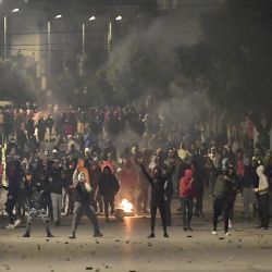 Los manifestantes se paran en medio del humo mientras bloquean una calle durante los enfrentamientos con las fuerzas de seguridad en el suburbio de la ciudad de Ettadhamen, en las afueras del noroeste de Túnez, la capital de Túnez, en medio de una ola de protestas nocturnas en el país del norte de África. | Foto:Fethi Belaid / AFP