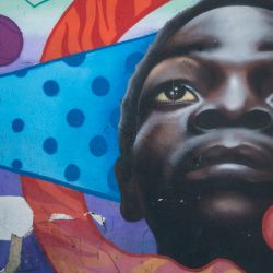 Una mujer con mascarilla se para junto a un mural callejero en Bogotá. - Bogotá entrará en confinamiento total el próximo fin de semana, por tercera vez consecutiva, debido al aumento de infecciones por coronavirus que mantiene a los hospitales en el Capital colombiana al borde del colapso. | Foto:Juan Barreto / AFP