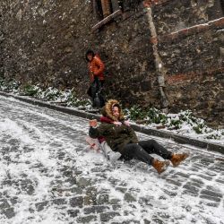 Niños se deslizan en una calle nevada en el distrito de Balat de Estambul. | Foto:Ozan Kose / AFP