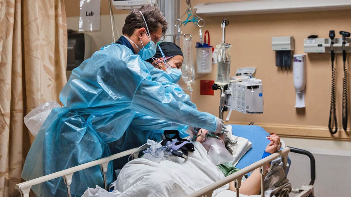 Health care workers tend to a Covid-19 patient in a Covid-19 holding pod at Providence St Mary Medical Center in Apple Valley, California.