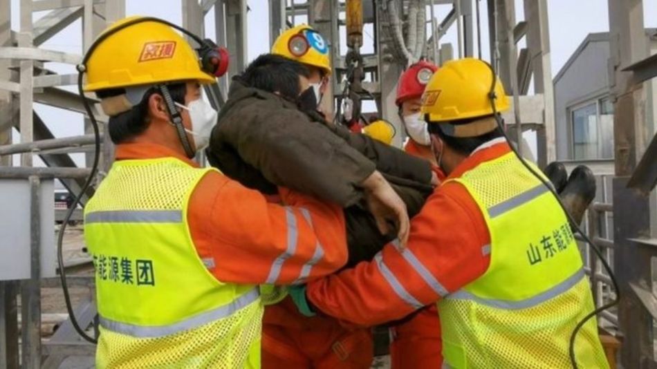 Uno de los mineros rescatados es trasladado por socorristas en la mina de oro de Qixia, en la provincia china de Shandong.