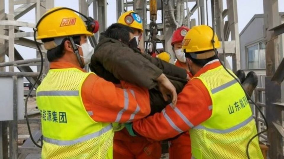 Uno de los mineros rescatados es trasladado por socorristas en la mina de oro de Qixia, en la provincia china de Shandong.