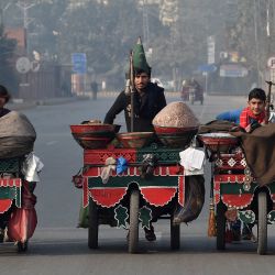 Los vendedores ambulantes tiraron de sus carros por una calle de Lahore. | Foto:Arif Ali / AFP