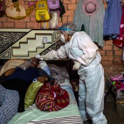 Un paciente de Covid-19 yace en su cama durante una visita médica en su casa en las afueras del este de Lima, en medio de la pandemia del nuevo coronavirus COVID-19. Los Equipos de Respuesta Rápida del Ministerio de Salud visitan a los pacientes potenciales y en recuperación de COVID-19 en sus hogares para realizar pruebas rápidas, hacer diagnósticos y distribuir medicamentos. | Foto:AFP