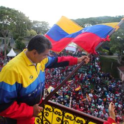 Imagen del folleto difundido por la Presidencia venezolana que muestra al presidente de Venezuela, Nicolás Maduro, ondeando la bandera nacional venezolana durante una reunión para conmemorar el 63 aniversario de la Insurrección Popular en el Palacio Presidencial de Miraflores en Caracas. | Foto:Handout / Presidencia venezolana / AFP
