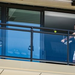 El personal de apoyo (izquierda) y el tenista número uno del mundo serbio, Novak Djokovic (derecha), juegan al tenis en un balcón donde están en cuarentena en el M Suites en North Adelaide en Adelaide, Australia del Sur, antes del Abierto de Australia Torneo de tenis. | Foto:Morgan Sette / AFP