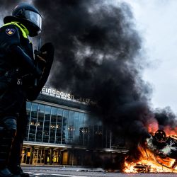 Un coche fue incendiado frente a la estación de tren, en Eindhoven, luego de una manifestación de varios cientos de personas contra la política de la corona. | Foto:Rob Engelaar / ANP / AFP