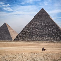 Un hombre monta un caballo frente a las pirámides de Khufu (Keops), Khafre (Chephren), en la necrópolis de las pirámides de Giza, en las afueras al suroeste de la capital egipcia, El Cairo. | Foto:Anne-Christine Poujoulat / AFP