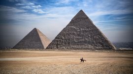 Un hombre monta un caballo frente a las pirámides de Khufu (Keops), Khafre (Chephren), en la necrópolis de las pirámides de Giza, en las afueras al suroeste de la capital egipcia, El Cairo.