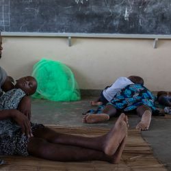 Una mujer sostiene a un niño dentro de un aula donde encontraron refugio en la escuela primaria 12 de Octubre en Beira, Mozambique, luego de ser desplazada por el ciclón Eloise que tocó tierra en Beira. | Foto:Alfredo Zuniga / AFP