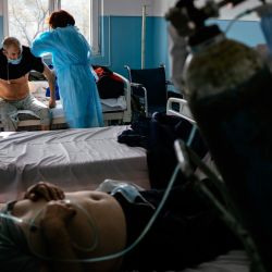 Esta fotografía muestra a un médico y una enfermera examinando a pacientes en la unidad Covid-19 del hospital de Doupnitsa, un municipio de 50.000 habitantes que carece desesperadamente de cuidadores. | Foto:Dimitar Dilkoff / AFP