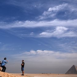 La gente toma fotografías frente a las pirámides de Khufu (Keops), Khafre (Chephren), en la necrópolis de las pirámides de Giza en las afueras al suroeste de la capital egipcia El Cairo. | Foto:Anne-Christine Poujoulat / AFP