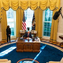 La vicepresidenta Kamala Harris observa mientras el presidente de los Estados Unidos, Joe Biden, habla con los periodistas antes de firmar acciones ejecutivas en la Oficina Oval de la Casa Blanca en Washington, DC. | Foto:Doug Mills-Pool / Getty Images / AFP