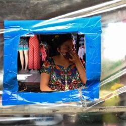 Se ve a un vendedor de comida detrás de una cortina de plástico como precaución contra la propagación del nuevo coronavirus, en un puesto del mercado El Guarda en la Ciudad de Guatemala. | Foto:Johan Ordonez / AFP
