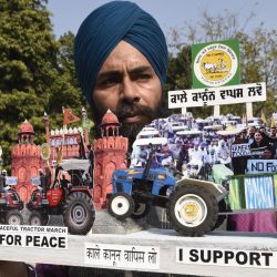 Un artista sostiene un modelo que representa a agricultores en tractores que protestan contra las recientes reformas agrícolas del gobierno central frente al Fuerte Rojo en Delhi, en Amritsar. | Foto:Narinder Nanu / AFP