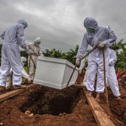 Los excavadores de tumbas entierran un ataúd de una víctima de Covid-19 en un cementerio especial en Bogor, cuando Indonesia superó más de un millón de casos de Covid-19, mientras el archipiélago lanza una de las campañas de vacunación más grandes del mundo para tomar medidas drásticas una tasa de infección vertiginosa. | Foto:AFP