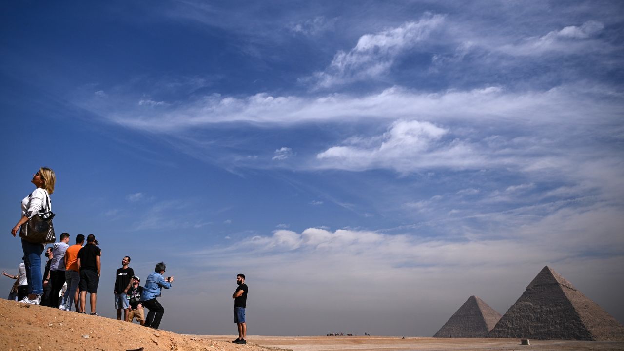 La gente toma fotografías frente a las pirámides de Khufu (Keops), Khafre (Chephren), en la necrópolis de las pirámides de Giza en las afueras al suroeste de la capital egipcia El Cairo. | Foto:Anne-Christine Poujoulat / AFP