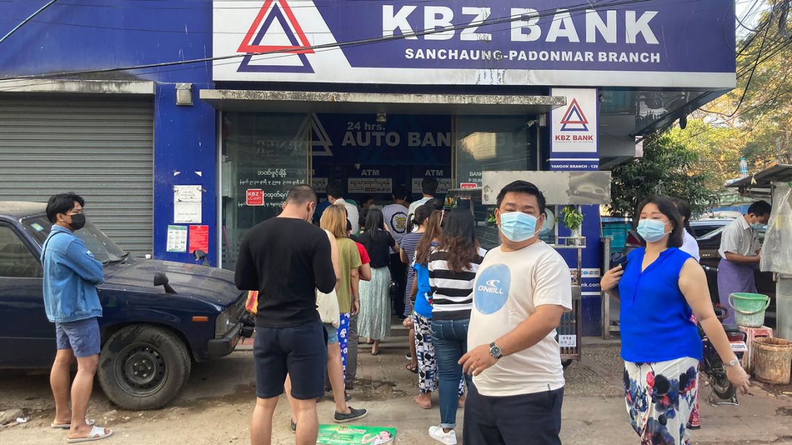 This picture obtained from the Twitter account @VegasBoyAHM shows people lined up at an ATM outside a closed branch of KBZ Bank in Yangon on February 1, 2021, following the military's move to detain the country's de facto leader Aung San Suu Kyi and the country's president in a coup. 