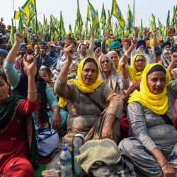 Los agricultores gritan consignas a lo largo de una carretera bloqueada mientras continúan su protesta contra las recientes reformas agrícolas del gobierno central en la frontera estatal de Delhi-Uttar Pradesh en Ghaziabad. | Foto:Prakash Singh / AFP