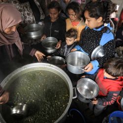 El cocinero voluntario palestino Amal Abu Amra, de 41 años, distribuye alimentos preparados con ingredientes obtenidos de donantes, para ayudar a las familias necesitadas en un barrio empobrecido de la ciudad de Gaza. | Foto:Mahmud Hams / AFP