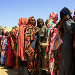 Mujeres sudanesas desplazadas esperan la llegada de la ayuda del Programa Mundial de Alimentos (PMA) al campo de desplazados internos de Otash, en las afueras de la ciudad de Nyala, la capital de Darfur del Sur. | Foto:Ashraf Shazly / AFP