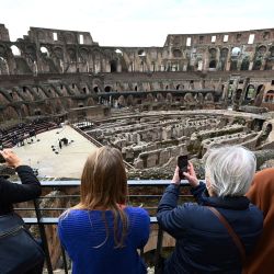 Los visitantes se toman fotografías mientras cantantes y músicos de la academia Santa Cecilia actúan en el emblemático Coliseo de Roma, que reabre en medio de una flexibilización de las restricciones al coronavirus. | Foto:Vincenzo Pinto / AFP